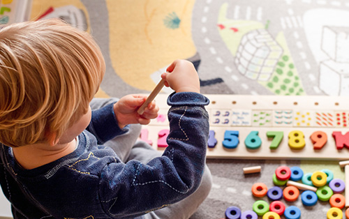 young child playing with blocks and numbers